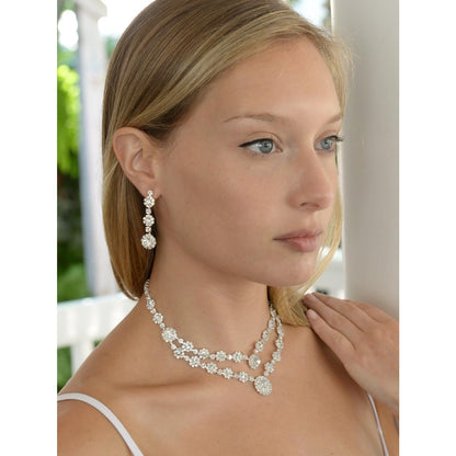 A woman wearing a white strapless top and a necklace 