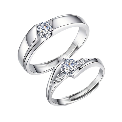 Two silver rings with one featuring a larger moissanite gemstone 